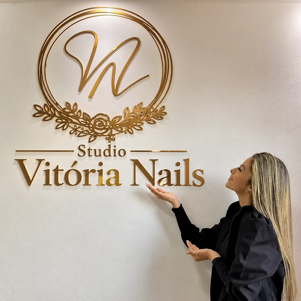 Espaço do Studio Vitória Nails com a identidade dourada na parede